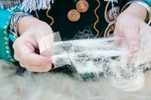 Image of Female Muslim hands works with wool