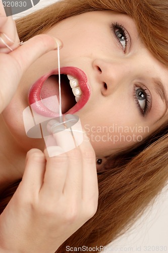 Image of Woman using dental floss