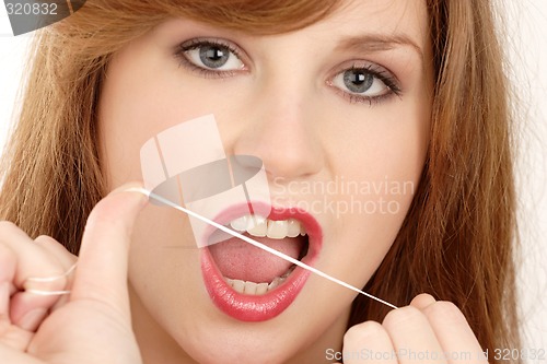Image of Woman using dental floss