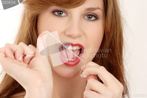 Image of Woman using dental floss