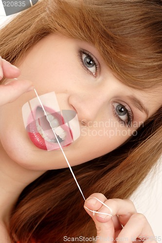 Image of Woman using dental floss