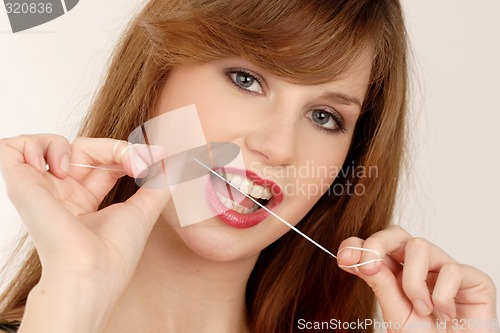 Image of Woman using dental floss