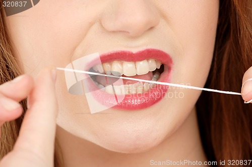 Image of Woman using dental floss