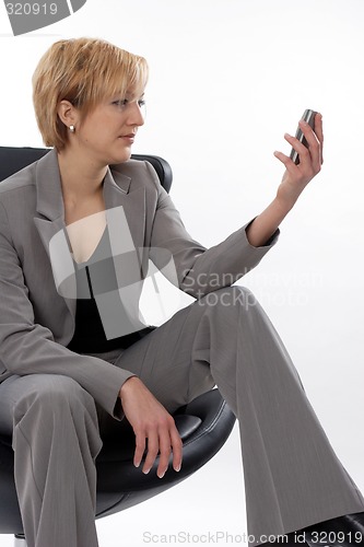 Image of Businesswoman looking at mobile phone