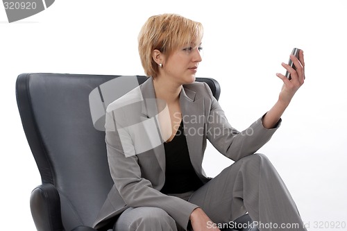 Image of Businesswoman looking at mobile phone