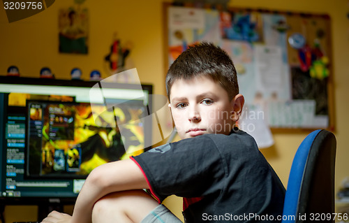 Image of Boy using computer at home, playing game