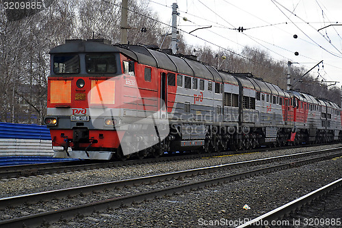 Image of The engine of gray color moves on railway tracks.