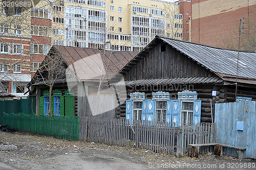 Image of Old wooden houses against modern high-rise buildings. Tyumen, Ru