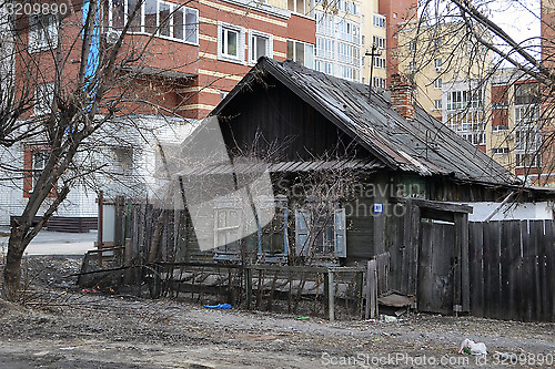 Image of Old wooden houses against modern high-rise buildings. Tyumen, Ru