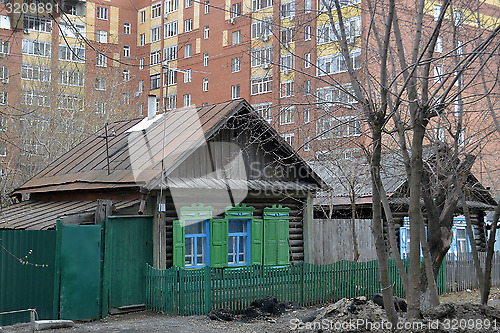 Image of Old wooden houses against modern high-rise buildings. Tyumen, Ru