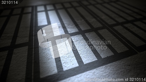 Image of Jail cells bars casting shadows on floor.