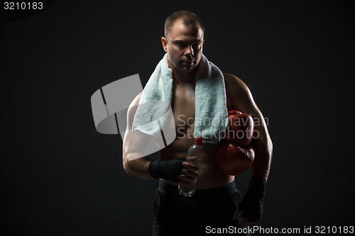 Image of boxer resting with water and a towel after training