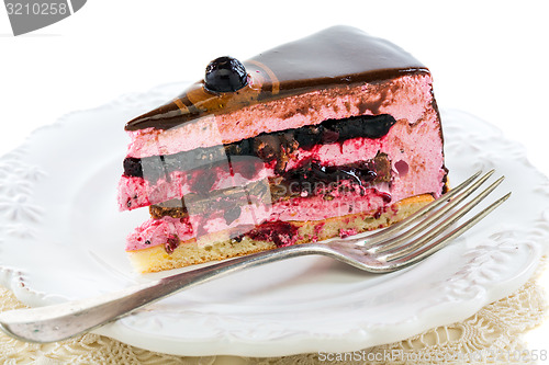 Image of Piece of cake with soufflé and fork on a white plate.