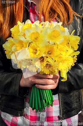 Image of figure girl with bouquet of daffodils in his hands