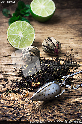 Image of tea brew with lime and mint on wooden background 