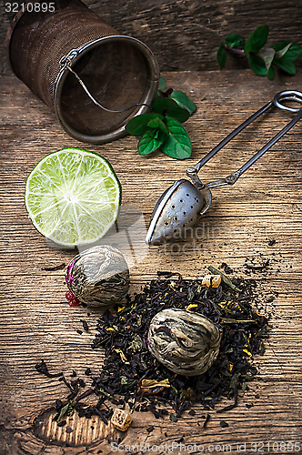 Image of tea brew with lime and mint on wooden background 