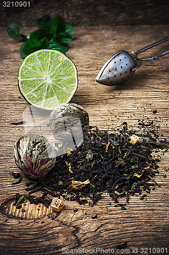 Image of tea brew with lime and mint on wooden background 