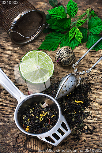 Image of tea brew with lime and mint on wooden background 