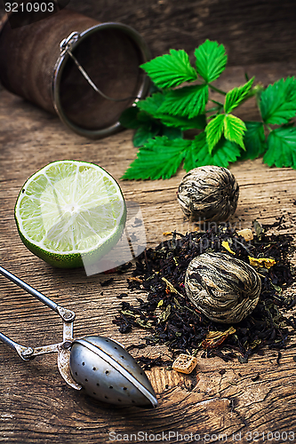 Image of tea brew with lime and mint on wooden background 