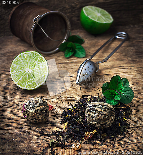 Image of tea brew with lime and mint on wooden background 