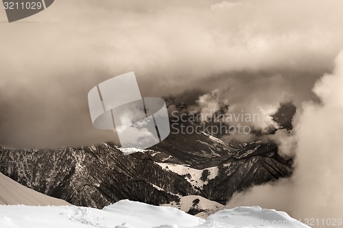 Image of Sepia snowy mountains in clouds