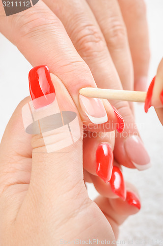 Image of manicure applying - cleaning the cuticles 