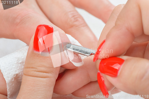 Image of manicure applying - cleaning the cuticles 