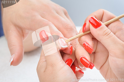 Image of manicure applying - cleaning the cuticles 