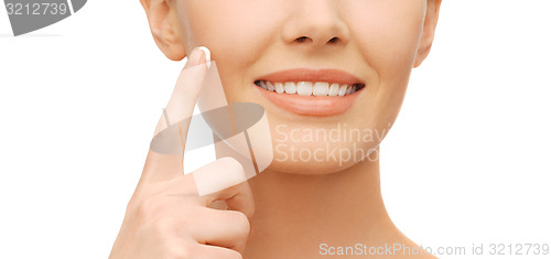 Image of beautiful woman applying moisturizing cream