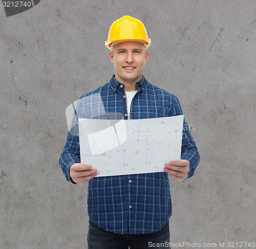 Image of smiling male builder in helmet with blueprint