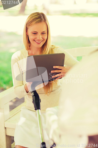 Image of happy mother with tablet pc and stroller in park