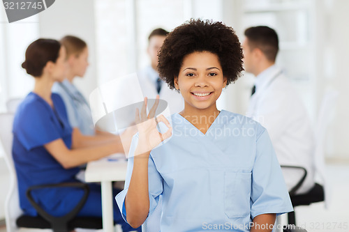 Image of happy doctor over group of medics at hospital