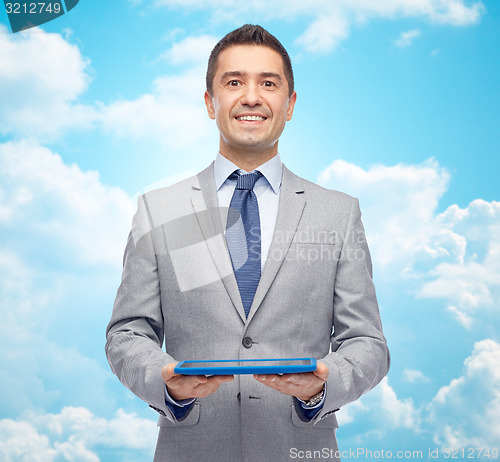 Image of happy businessman in suit holding tablet pc
