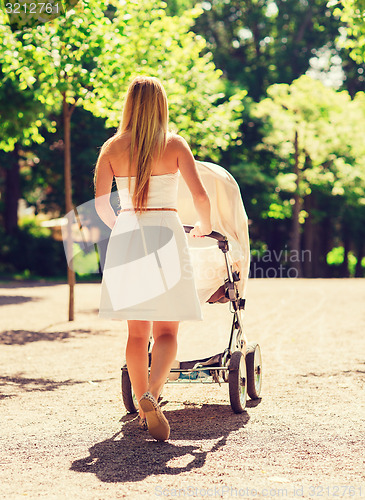 Image of happy mother with stroller in park