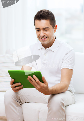 Image of smiling man working with tablet pc at home