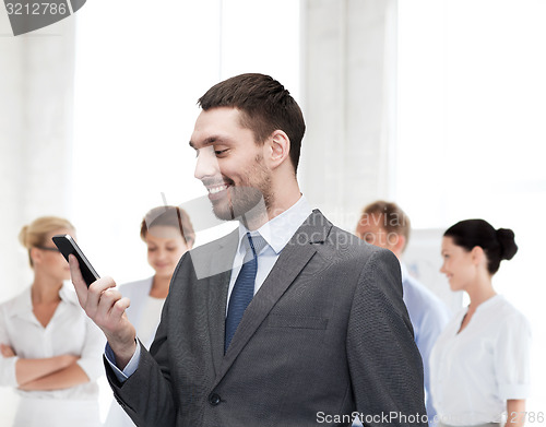 Image of young smiling businessman with smartphone