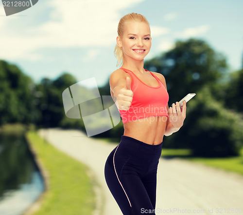 Image of smiling sporty woman with smartphone