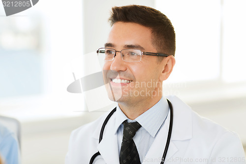 Image of smiling male doctor in white coat and eyeglasses