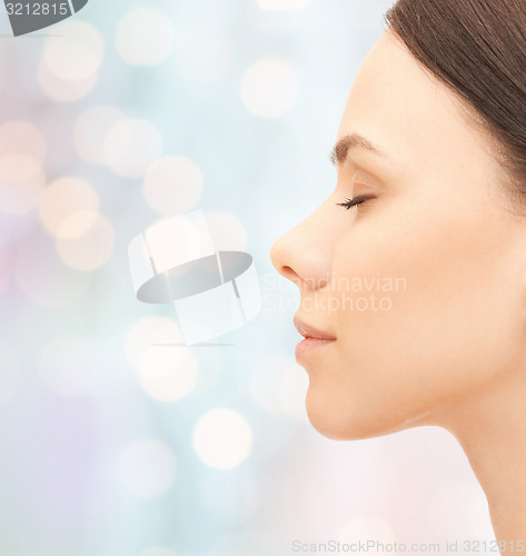 Image of beautiful young woman face over blue background