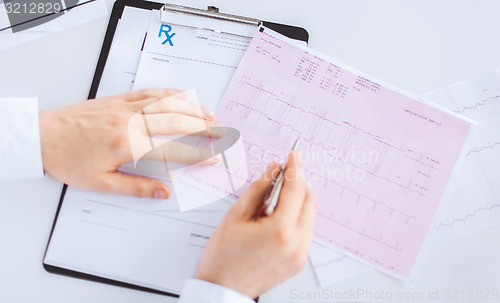 Image of male doctor hands with cardiogram