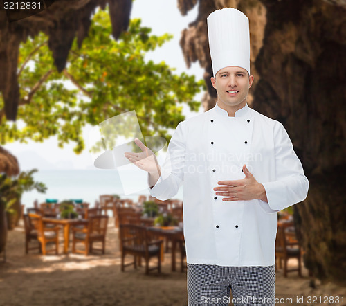 Image of happy male chef cook inviting