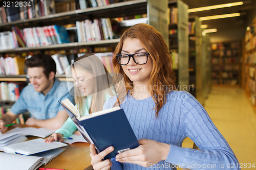 Image of happy students reading books in library