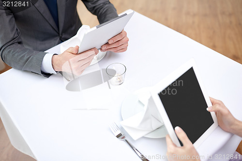 Image of close up of couple with tablet pc at restaurant