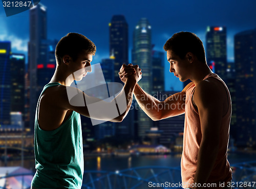 Image of two young men arm wrestling