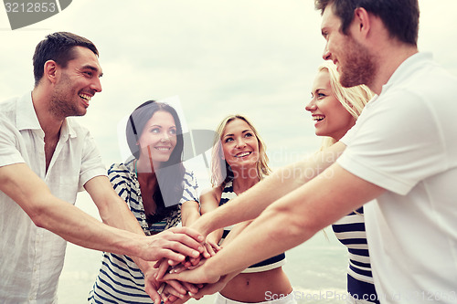 Image of smiling friends putting hands on top of each other