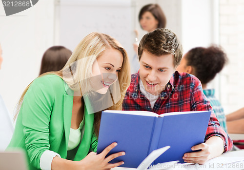 Image of students reading book at school