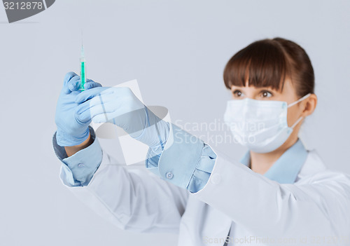 Image of female doctor holding syringe with injection