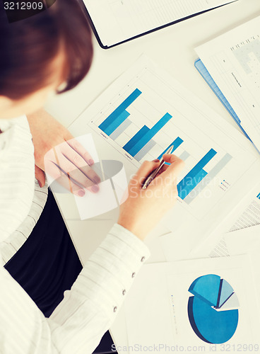 Image of woman hand with charts and papers