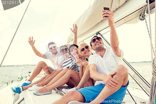 Image of smiling friends sitting on yacht deck