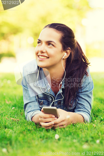 Image of smiling young girl with smartphone and earphones